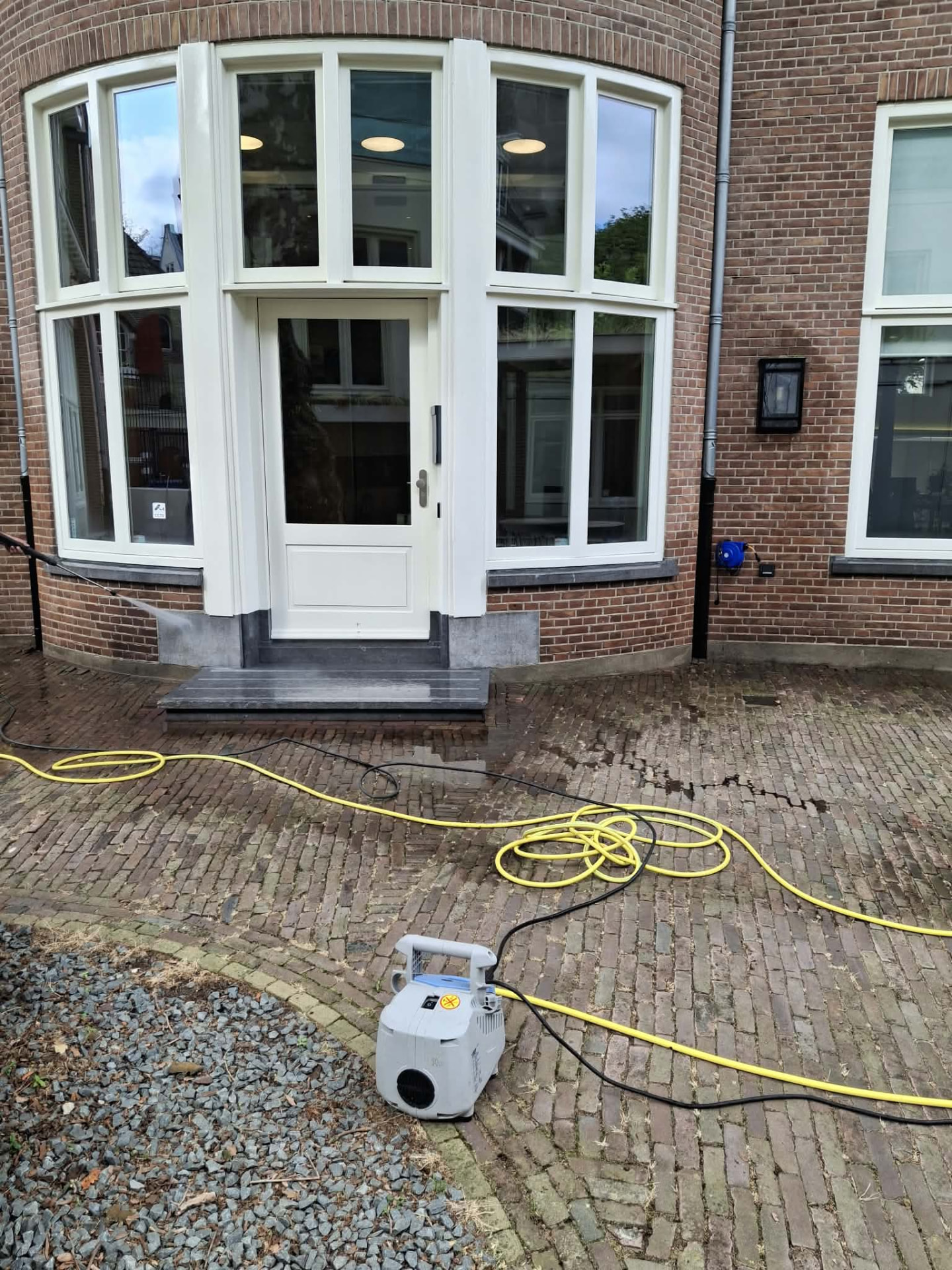 Gevel- en bestratingreiniging met hogedruk bij een kantoorvilla