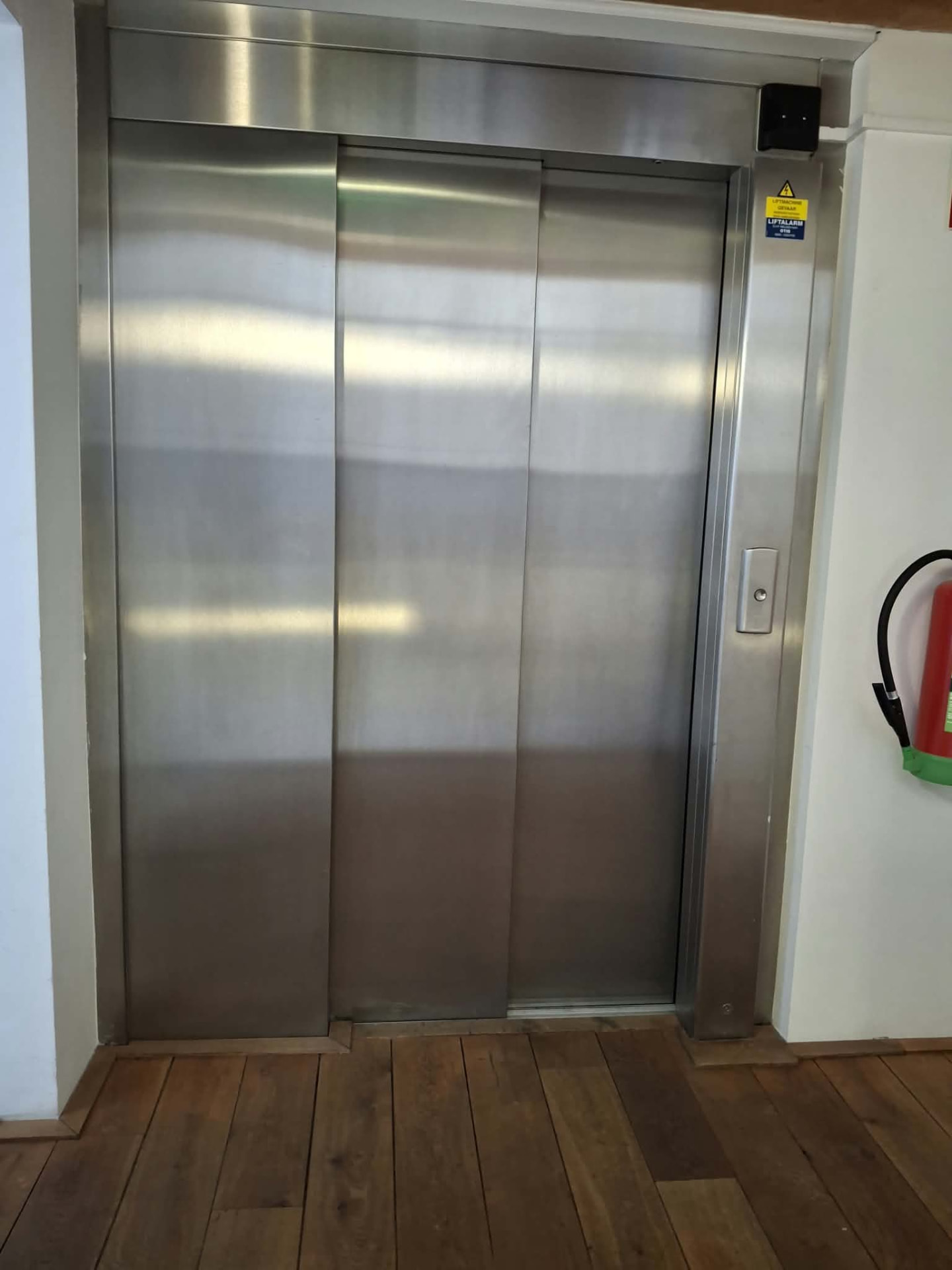Gepolijste rvs liftdeuren in een gereinigd trappenhuis